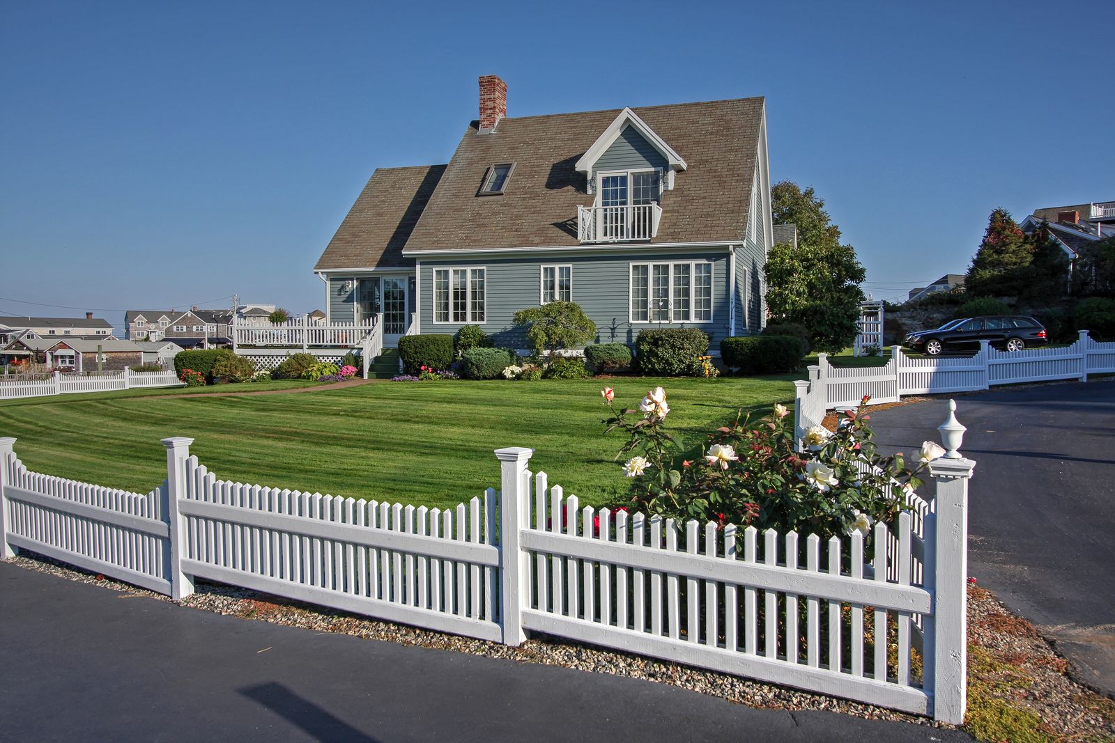White picket fence surrounding a suburban home